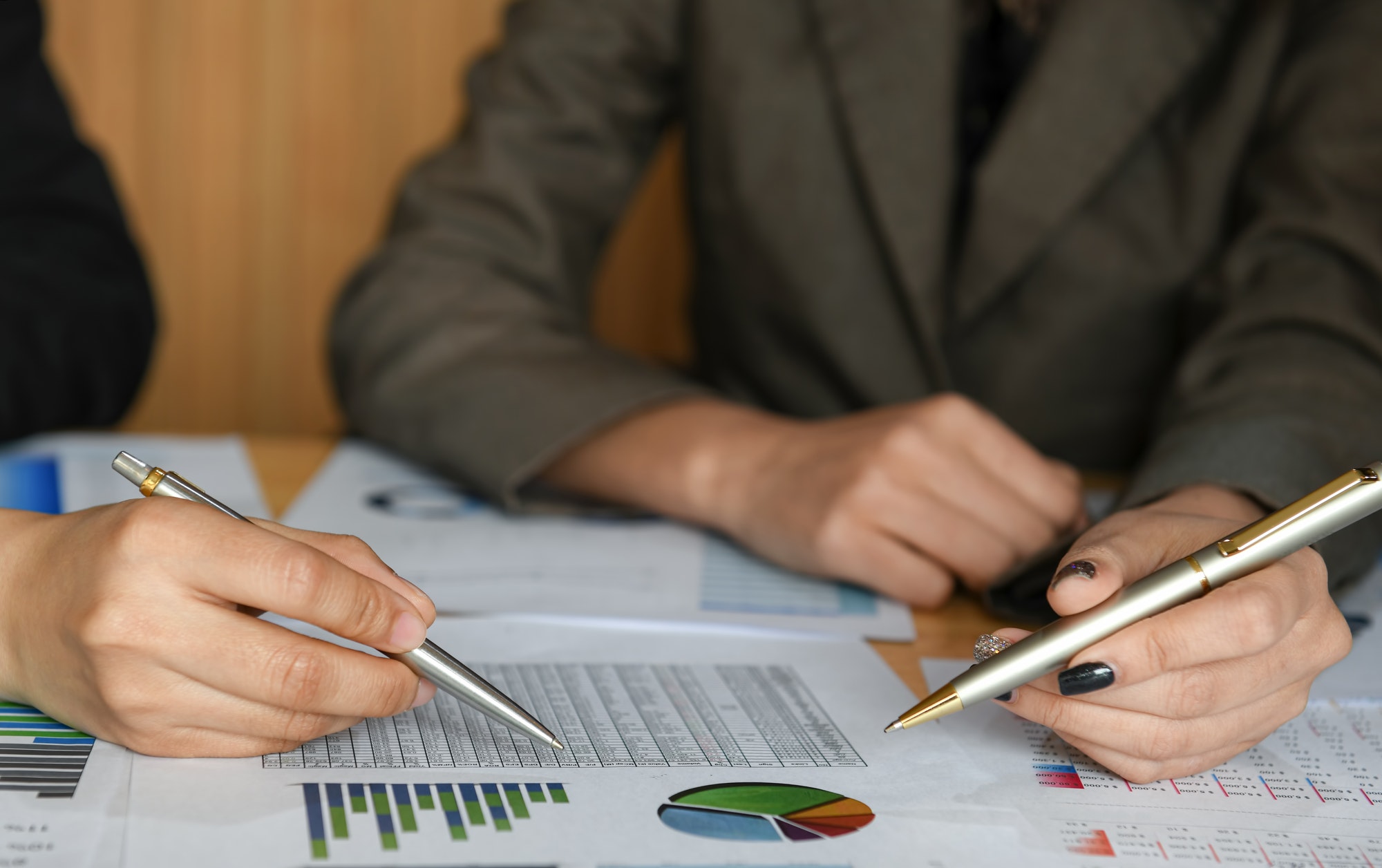 Female accountant team is calculating the budget to present executives.